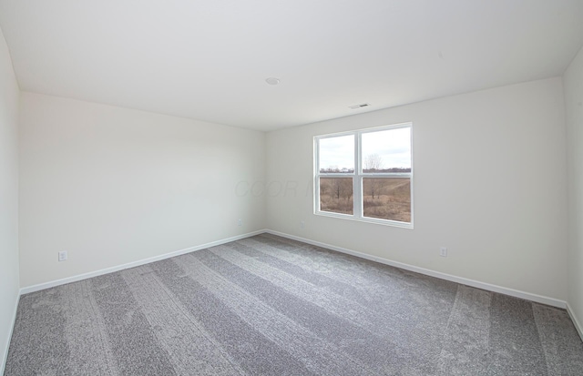 carpeted spare room featuring baseboards and visible vents