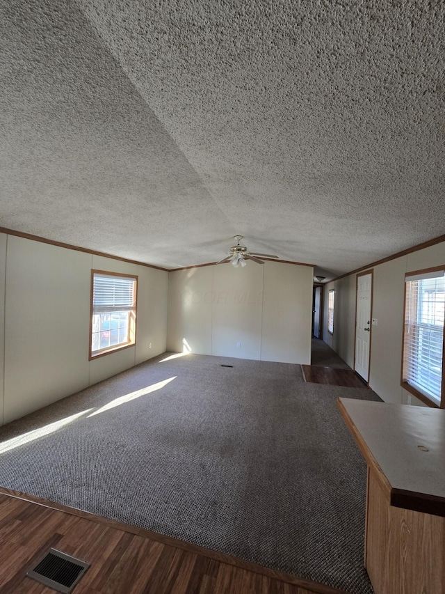 unfurnished living room featuring dark hardwood / wood-style floors, a textured ceiling, and a wealth of natural light