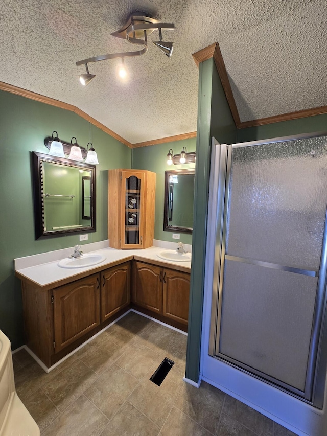 bathroom with vaulted ceiling, a shower with door, and a textured ceiling