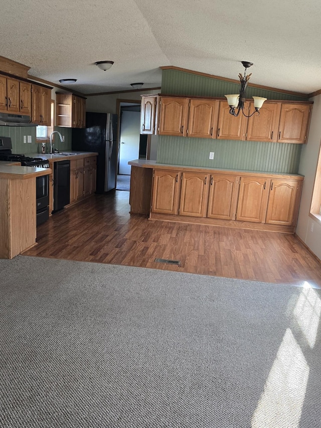 kitchen featuring black appliances, a chandelier, dark wood-type flooring, and vaulted ceiling