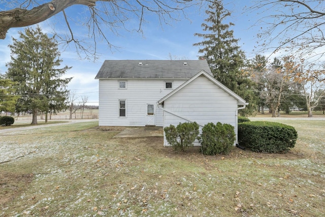 view of side of property with a patio area and a lawn