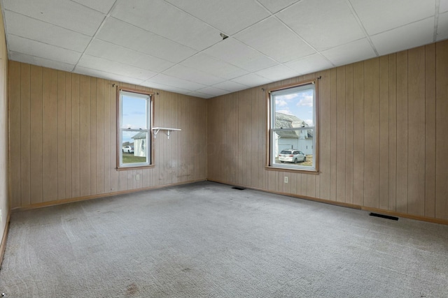 unfurnished room with a drop ceiling and light colored carpet