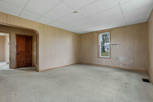 empty room with a paneled ceiling and light carpet