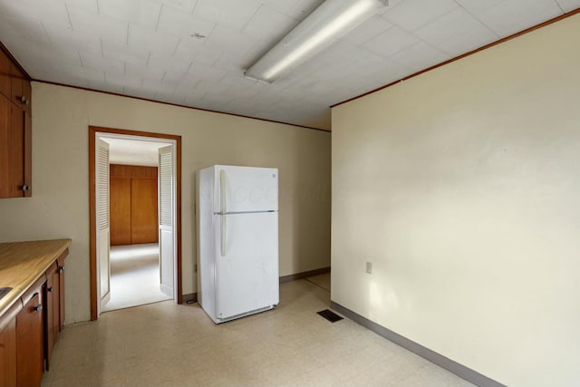 kitchen featuring white refrigerator and ornamental molding