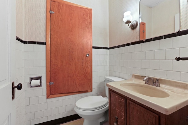 bathroom with vanity, toilet, tile walls, and tasteful backsplash