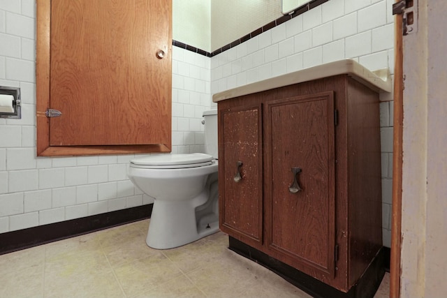 bathroom with toilet and tile walls