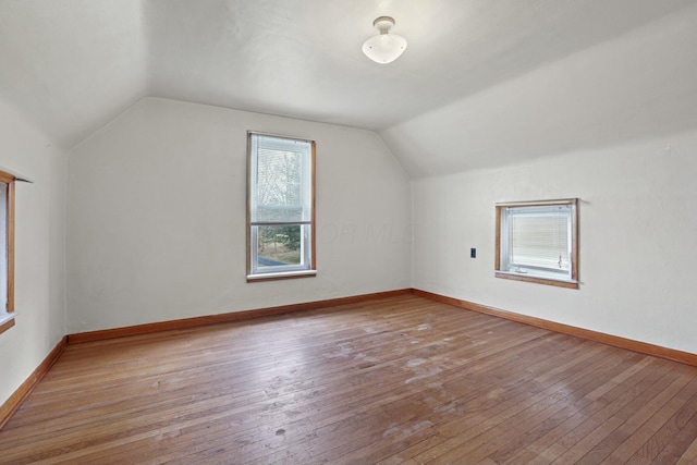 bonus room with light wood-type flooring and vaulted ceiling