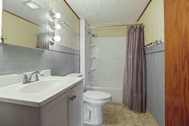 full bathroom with vanity, toilet, shower / bath combo with shower curtain, and tile walls