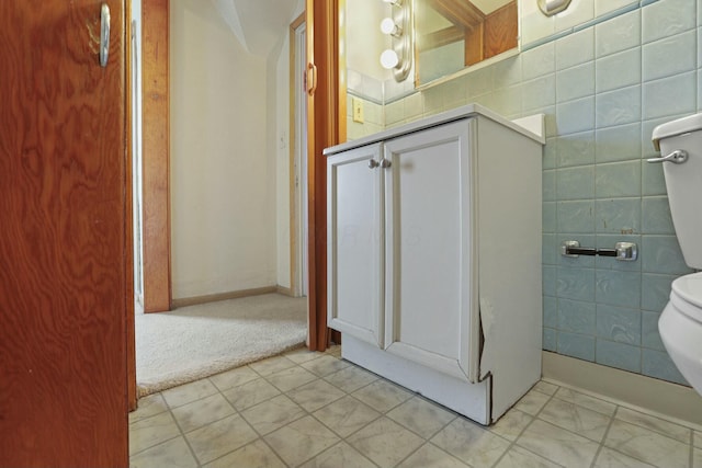 bathroom with toilet and tile walls