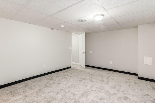 empty room with a paneled ceiling and light colored carpet