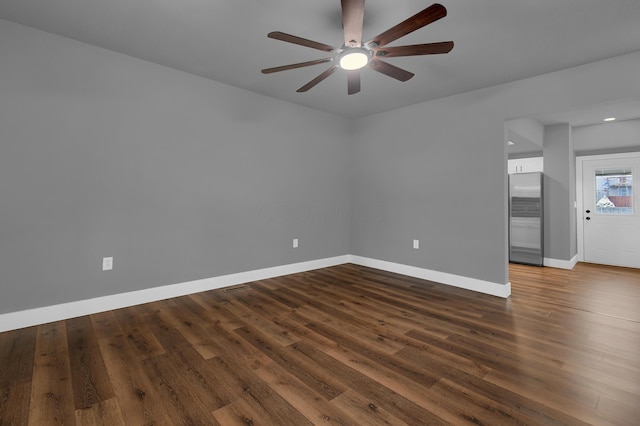 spare room featuring dark wood-type flooring and ceiling fan