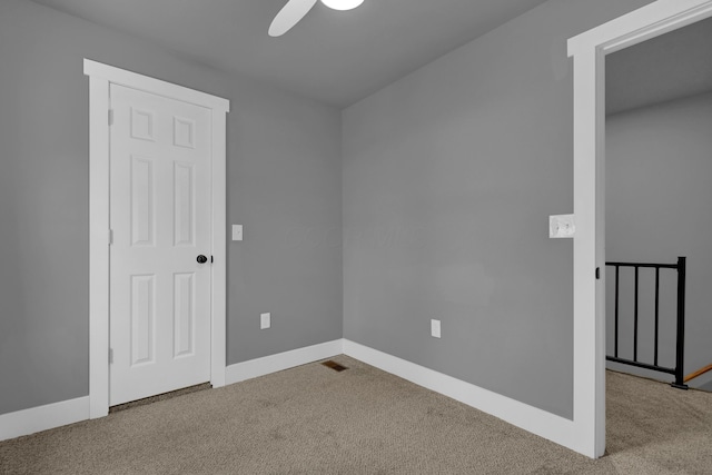 carpeted spare room featuring ceiling fan