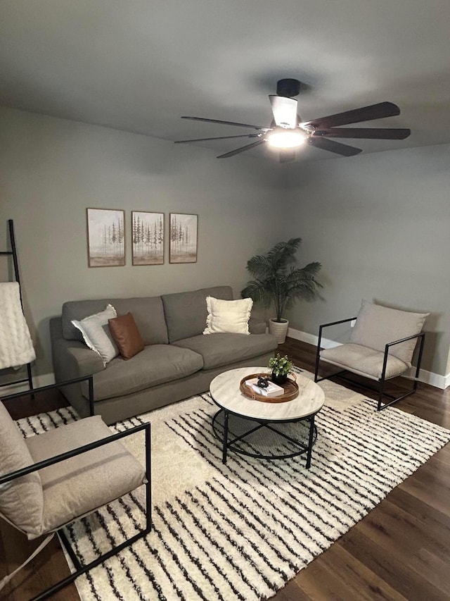 living room with dark wood-type flooring and ceiling fan