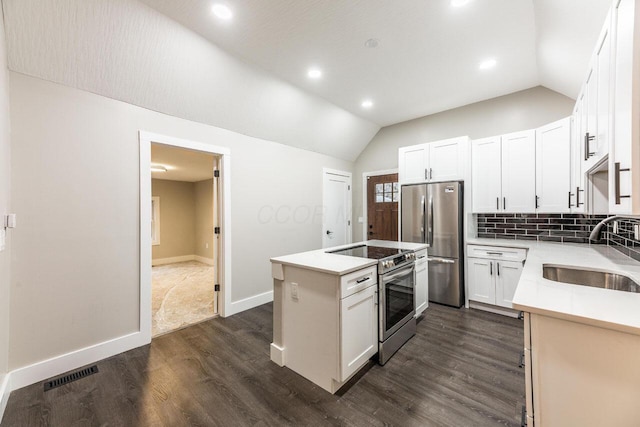 kitchen featuring sink, white cabinets, stainless steel appliances, and vaulted ceiling