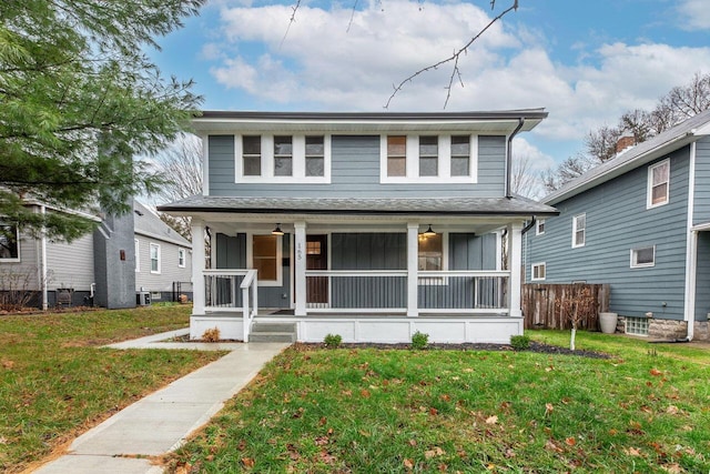 view of front of home with a front yard, central air condition unit, and covered porch