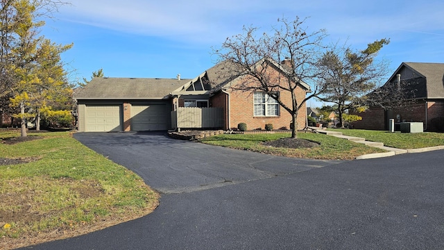 view of front facade featuring a garage, a front lawn, and cooling unit