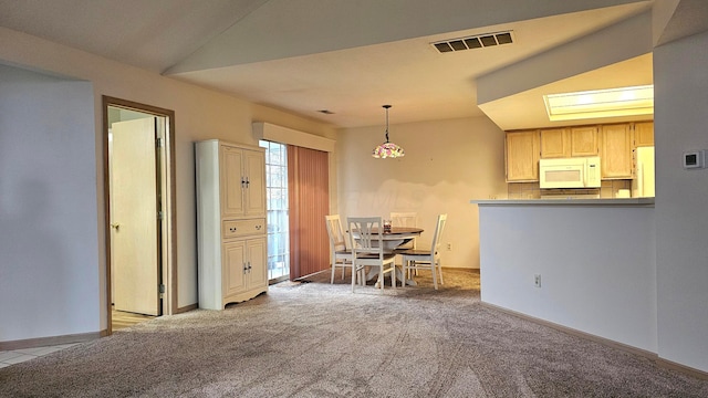 kitchen with white appliances, light brown cabinetry, tasteful backsplash, decorative light fixtures, and light colored carpet