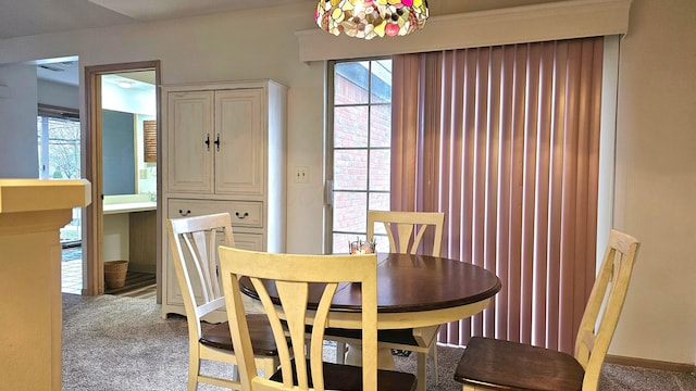 dining area with carpet floors and an inviting chandelier