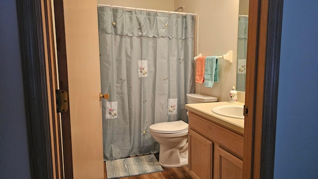 bathroom featuring hardwood / wood-style floors, vanity, toilet, and walk in shower