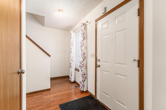 entrance foyer with light hardwood / wood-style floors and a textured ceiling