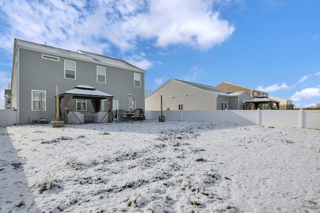 snow covered back of property featuring a gazebo