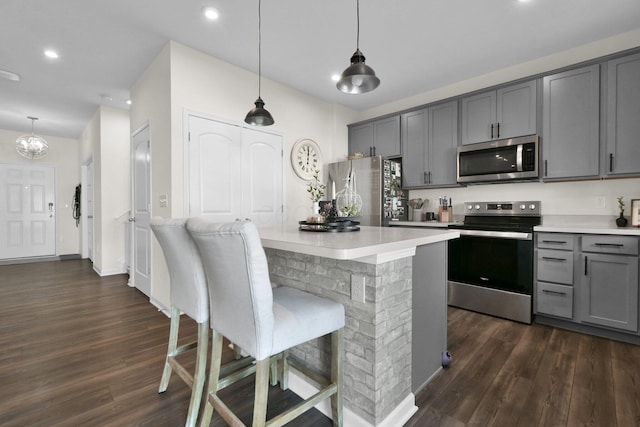 kitchen featuring appliances with stainless steel finishes, gray cabinets, and pendant lighting