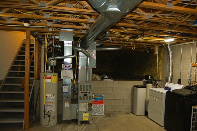 basement featuring gas water heater, heating unit, and washing machine and clothes dryer