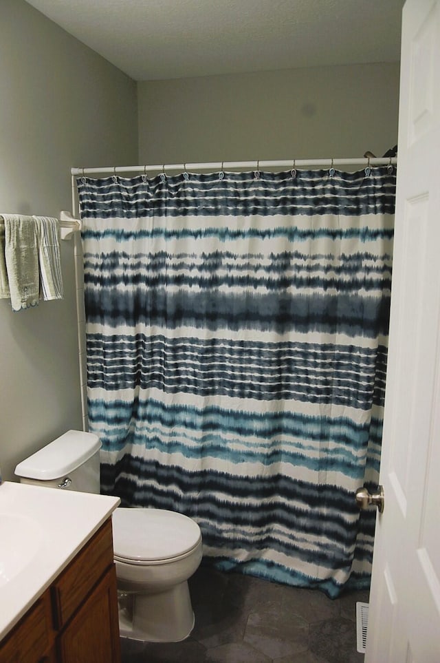 bathroom featuring a shower with curtain, vanity, and toilet