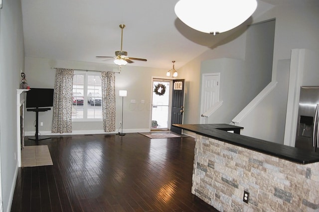 unfurnished living room featuring dark hardwood / wood-style floors, ceiling fan, and vaulted ceiling