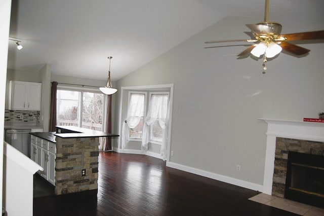 kitchen with white cabinets, dishwasher, a center island, and vaulted ceiling