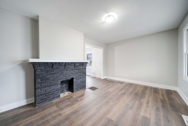 unfurnished living room featuring a fireplace and wood-type flooring