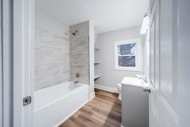 full bathroom featuring hardwood / wood-style flooring, vanity, tiled shower / bath combo, and toilet