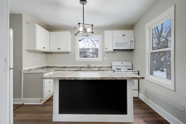 kitchen featuring white cabinetry, sink, white appliances, and decorative light fixtures