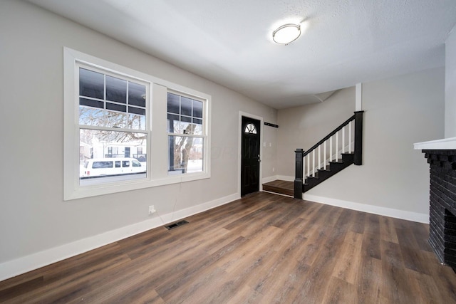 foyer featuring dark hardwood / wood-style flooring and a fireplace