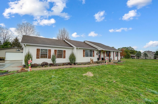 single story home with a porch, a garage, an outbuilding, and a front yard