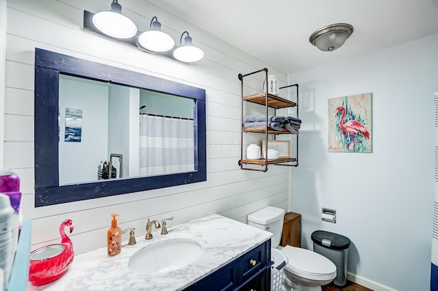 bathroom with a shower with curtain, wood walls, vanity, and toilet