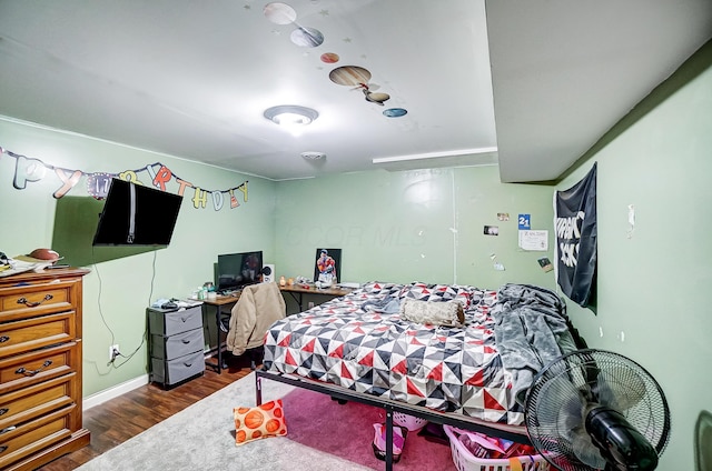 bedroom with dark hardwood / wood-style flooring