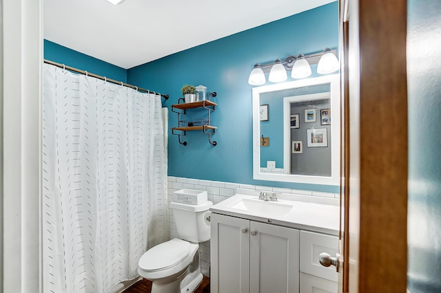 bathroom with a shower with shower curtain, vanity, toilet, and tile walls