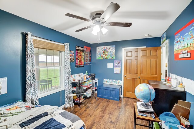 bedroom with a closet, hardwood / wood-style flooring, and ceiling fan