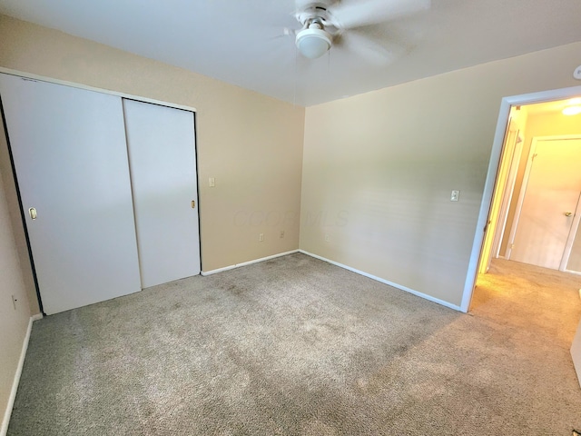 unfurnished bedroom featuring carpet flooring, ceiling fan, and a closet