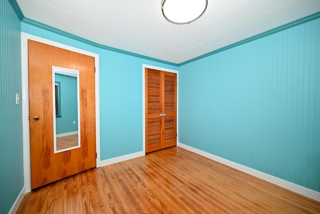 unfurnished bedroom with light hardwood / wood-style floors and a closet