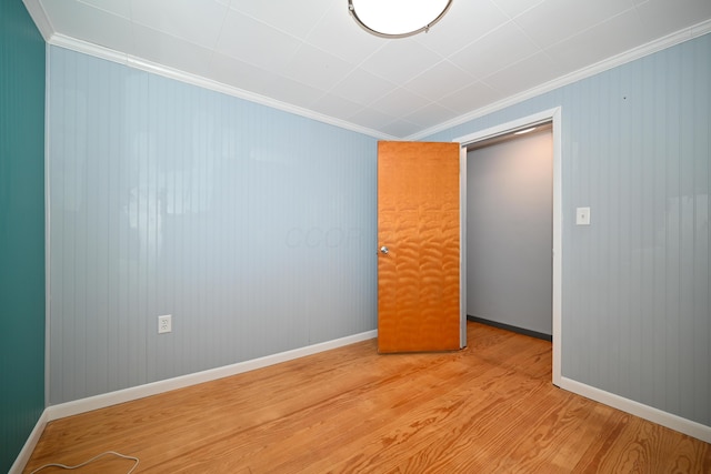 unfurnished bedroom featuring ornamental molding and light hardwood / wood-style floors