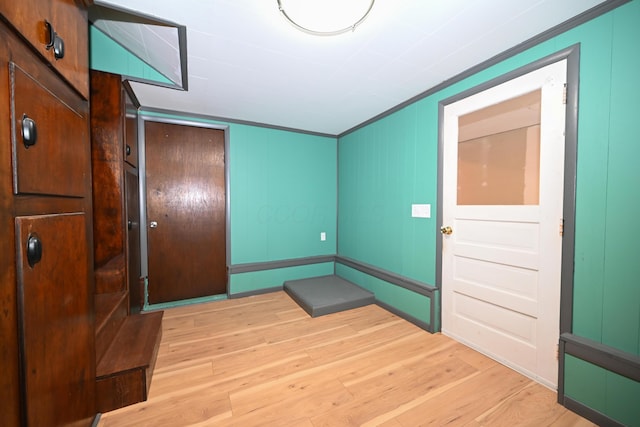 foyer with ornamental molding and light hardwood / wood-style floors