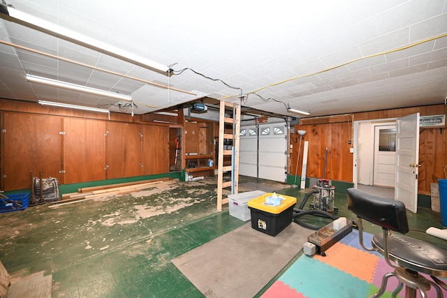 garage featuring a garage door opener and wooden walls