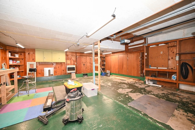 basement with heating unit, wooden walls, and a workshop area