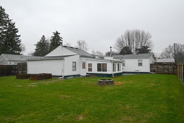 back of property featuring a yard and a fire pit