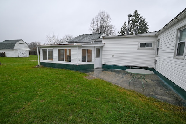 back of property with a storage unit, a patio area, and a lawn