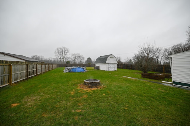 view of yard with an outbuilding, a covered pool, and an outdoor fire pit