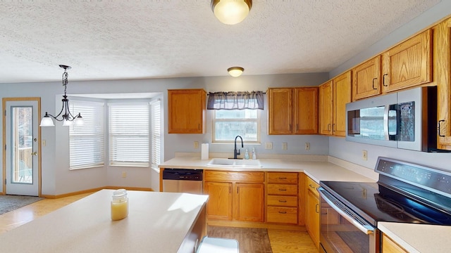 kitchen featuring sink, decorative light fixtures, a textured ceiling, appliances with stainless steel finishes, and a notable chandelier