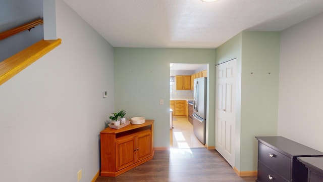 hallway featuring hardwood / wood-style floors and a textured ceiling